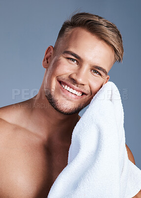 Buy stock photo Shot of a handsome young man drying his face with a towel