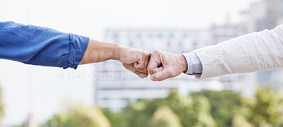 Buy stock photo Shot of two unrecognizable business people fist bumping outside