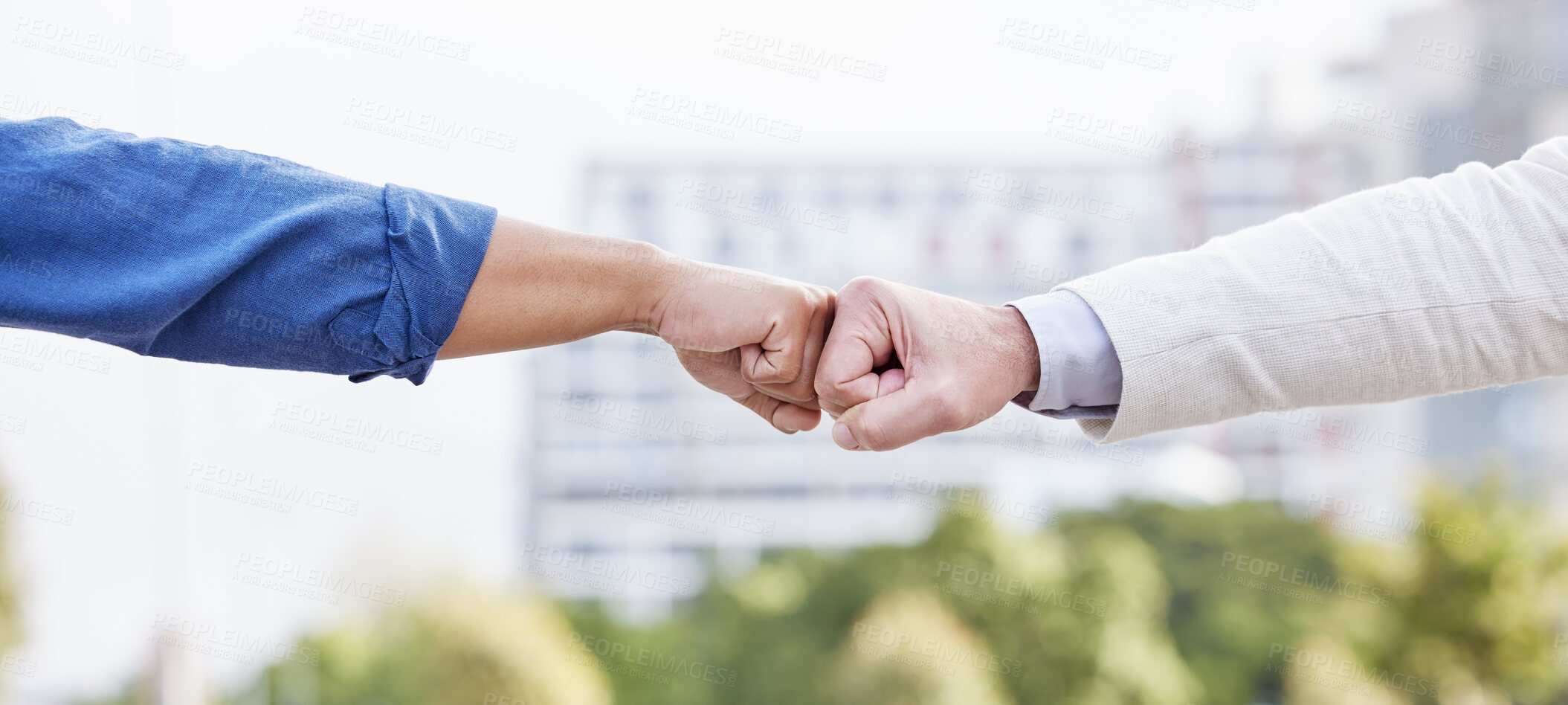 Buy stock photo Shot of two unrecognizable business people fist bumping outside