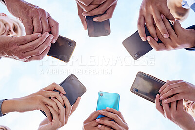 Buy stock photo Closeup shot of a group of businesspeople using their cellphones in synchronicity outside