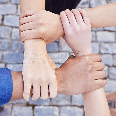 Buy stock photo Cropped shot of a group of businesspeople linking their arms in solidarity at work