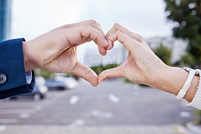 Buy stock photo Shot of an unrecognizable couple making a heart gesture with their hands outside