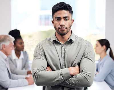 Buy stock photo Portrait, serious and a business man arms crossed in the boardroom with his team planning in the background. Leadership, workshop and focus with a confident young male employee standing in the office