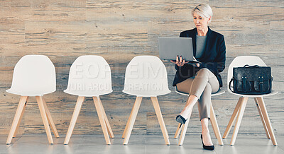 Buy stock photo Shot of a mature businesswoman using a laptop while waiting in line at an office
