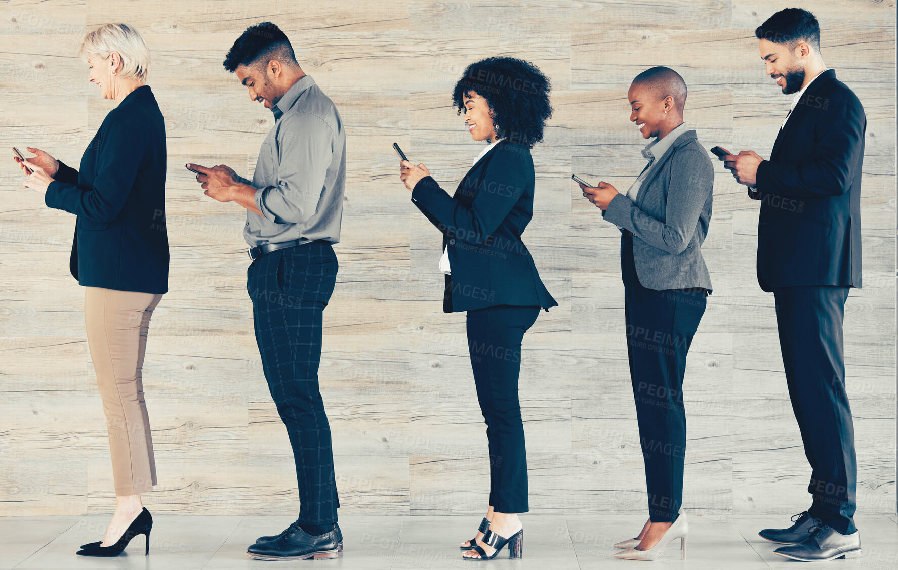 Buy stock photo Shot of a group of businesspeople waiting in line and using a phone at an office