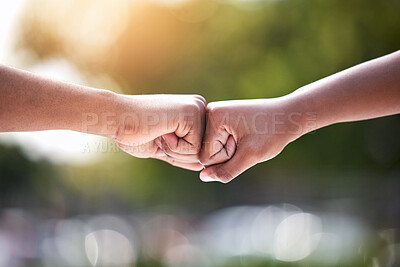 Buy stock photo Shot of two unrecognizable people giving each other a fist bump outside