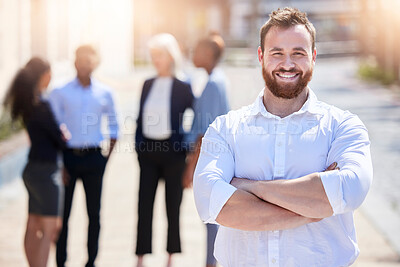 Buy stock photo Shot of a young businessman standing with his arms crossed outside
