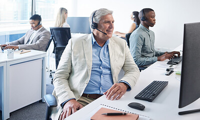 Buy stock photo Shot of a mature businessman using a headset and computer in a modern office