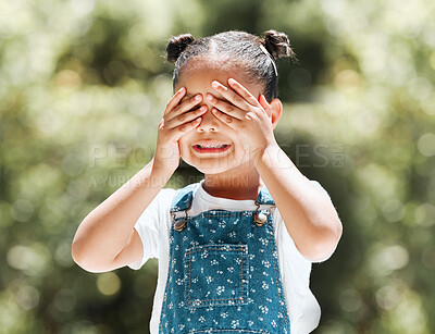 Buy stock photo Shot of an adorable little girl covering her eyes while standing outside