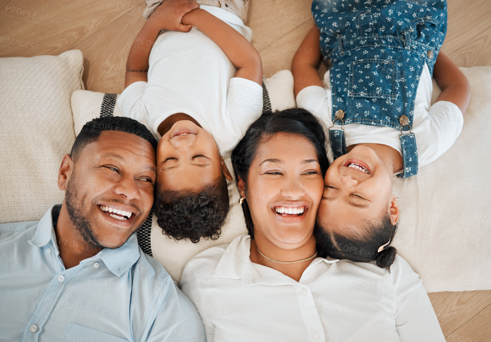 Buy stock photo Laughing, family and smile in home above, bonding and fun on living room floor in house. Parents, African couple and happy children with mother and father for love, relax and together in lounge