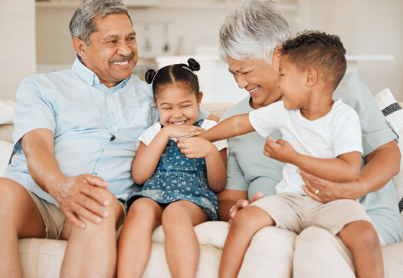 Buy stock photo Shot of grandparents bonding with their grandchildren on a sofa at home