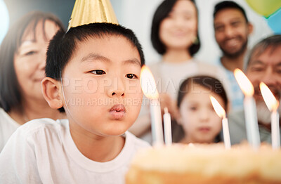 Buy stock photo Shot of an adorable little boy celebrating a birthday with his family at home