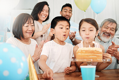 Buy stock photo Shot of an adorable little boy and girl celebrating a birthday with their family at home