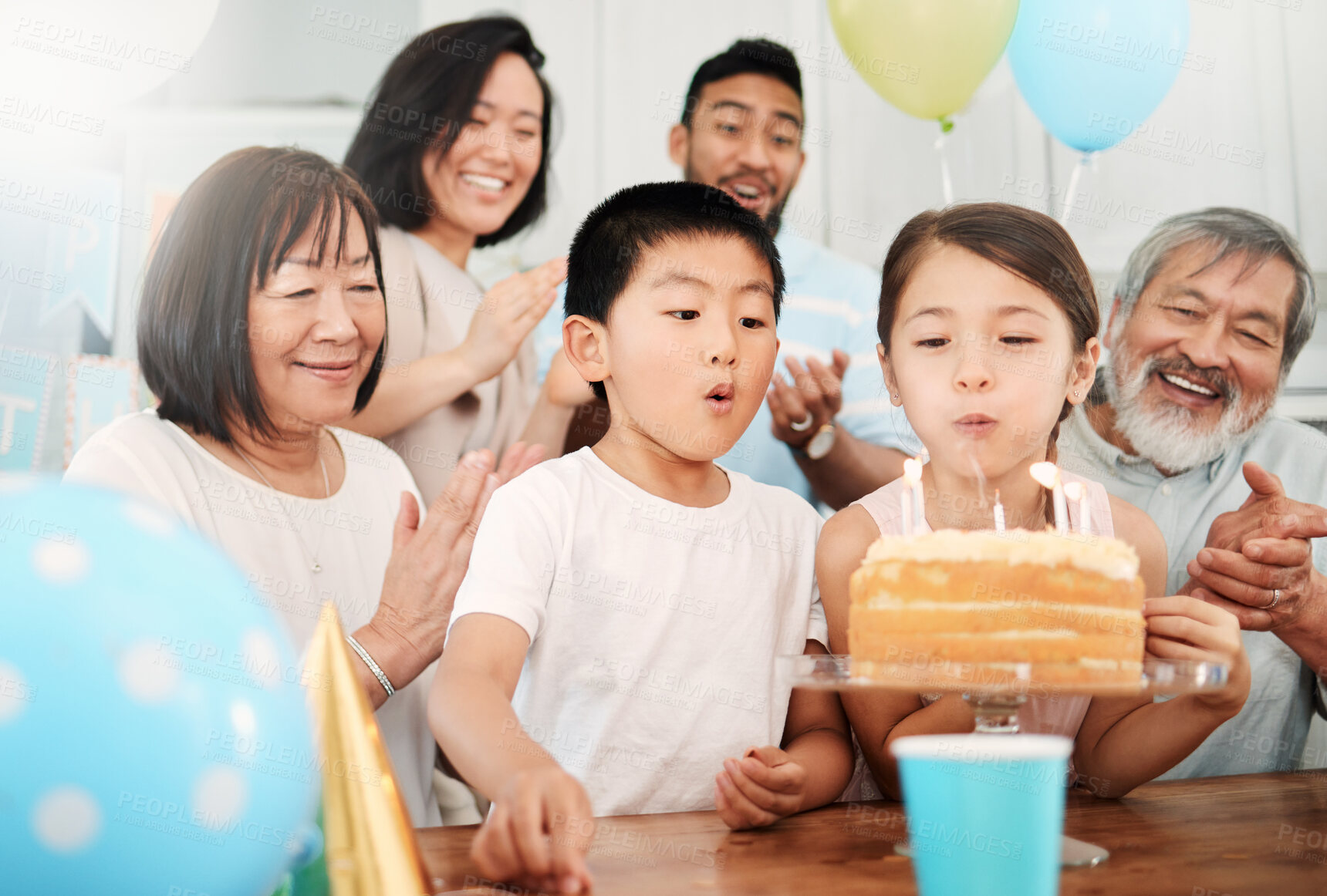 Buy stock photo Shot of an adorable little boy and girl celebrating a birthday with their family at home
