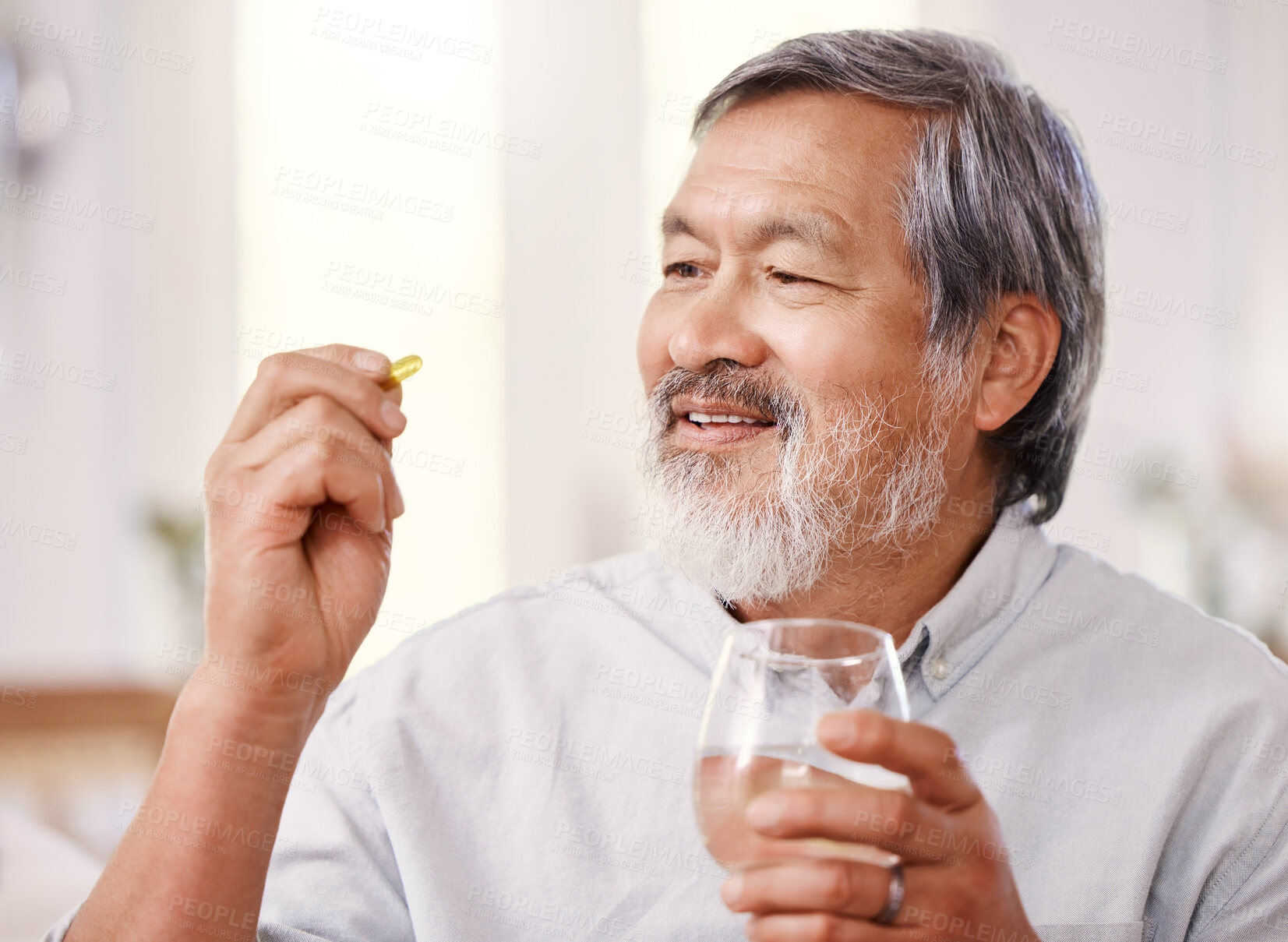 Buy stock photo Shot of a senior man holding medication and a glass of water