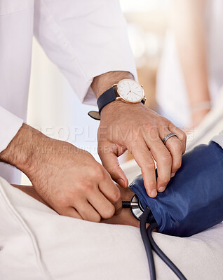 Buy stock photo Shot of a male doctor examining a senior patient with a blood pressure gauge