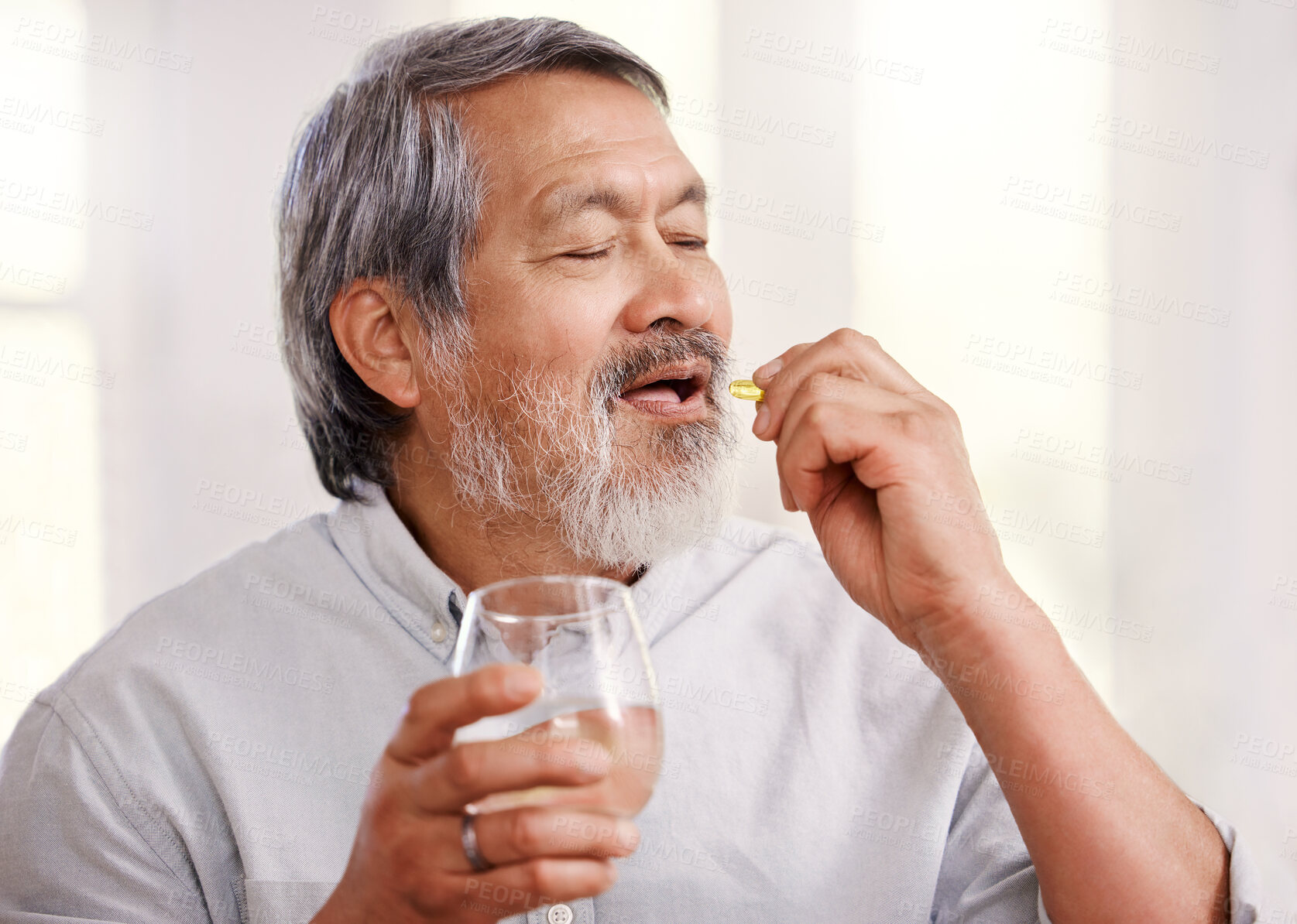 Buy stock photo Shot of a senior man holding medication and a glass of water