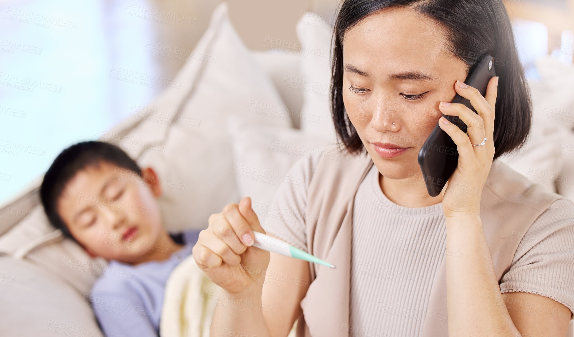 Buy stock photo Shot of a woman talking on the phone after taking her child's temperature