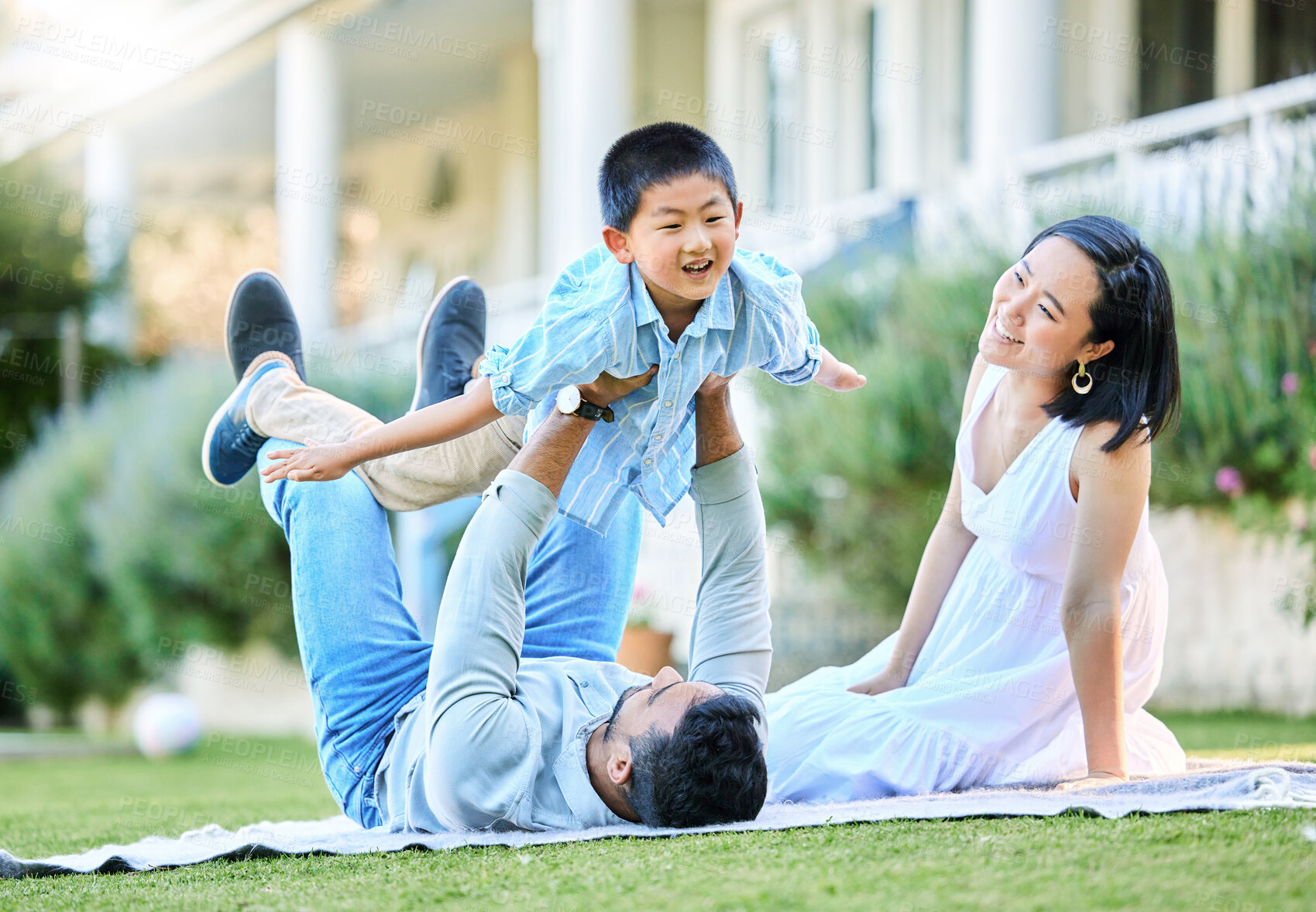 Buy stock photo Shot of a young family relaxing in their garden outside