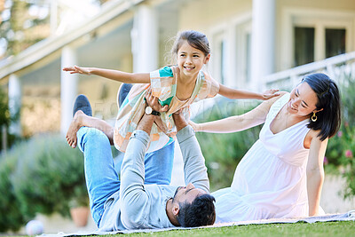 Buy stock photo Shot of a young family relaxing in their garden outside