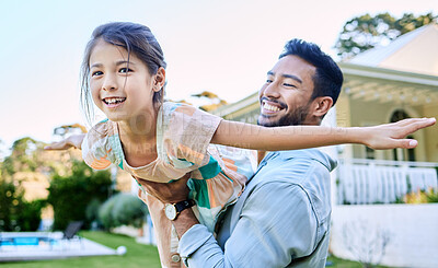 Buy stock photo Shot of a young father holding up his daughter in the garden outside