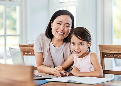 Buy stock photo Shot of a young mother helping her daughter with her homework at home