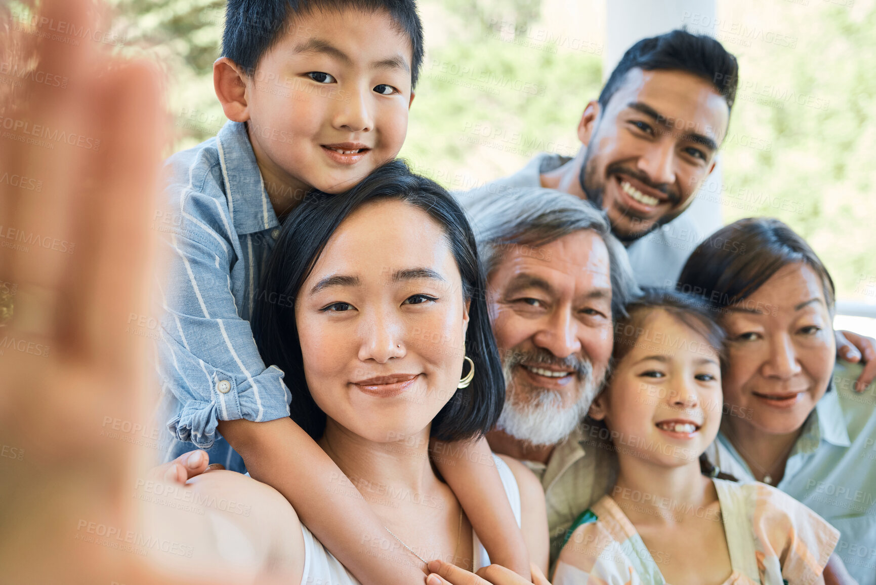 Buy stock photo Shot of a happy family taking selfies in a garden