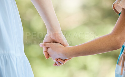 Buy stock photo Shot of an unrecognisable little girl and her mother holding hands in a garden