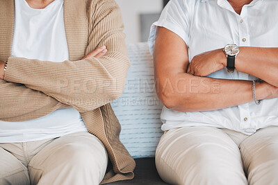 Buy stock photo Closeup shot of an unrecognisable couple sitting with their arms crossed during an argument at home