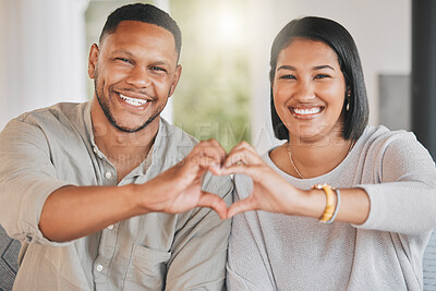 Buy stock photo Portrait of a young couple making a heart shape with their hands at home