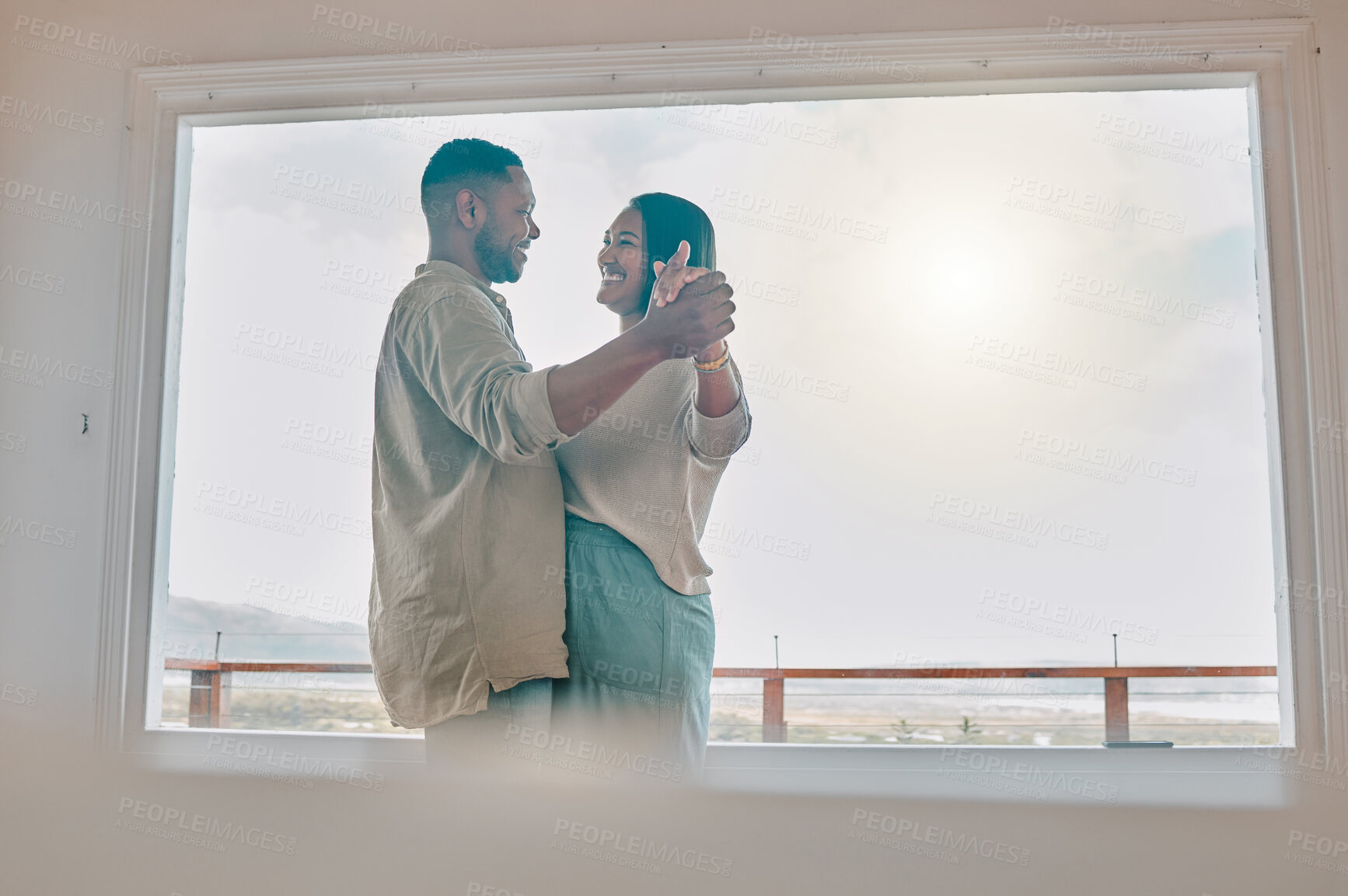 Buy stock photo Shot of a young couple dancing together at home