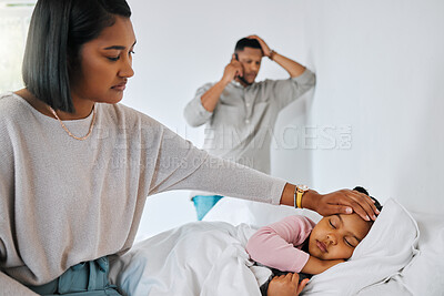 Buy stock photo Shot of a young mother feeling her sick child's forehead at home