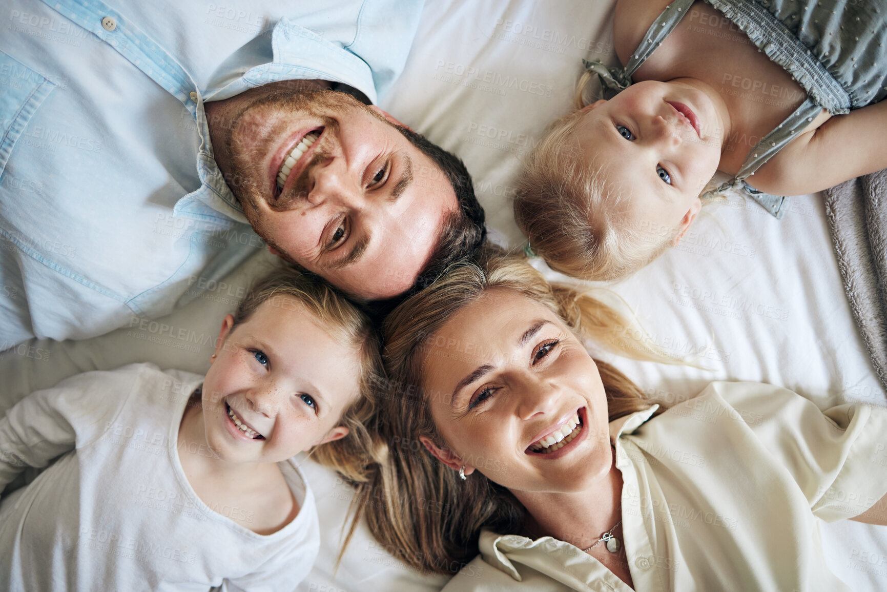 Buy stock photo Portrait, happy and children with parents on bed for bonding, security and having fun together. Relax, home and girl kids laying with mom and dad for resting in bedroom at house in London from above.