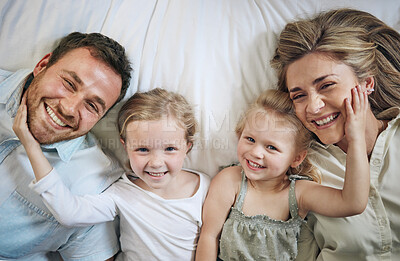 Buy stock photo Portrait, smile and children with parents on bed for bonding, security and having fun together. Relax, home and girl kids laying with mom and dad for resting in bedroom at house in London from above.