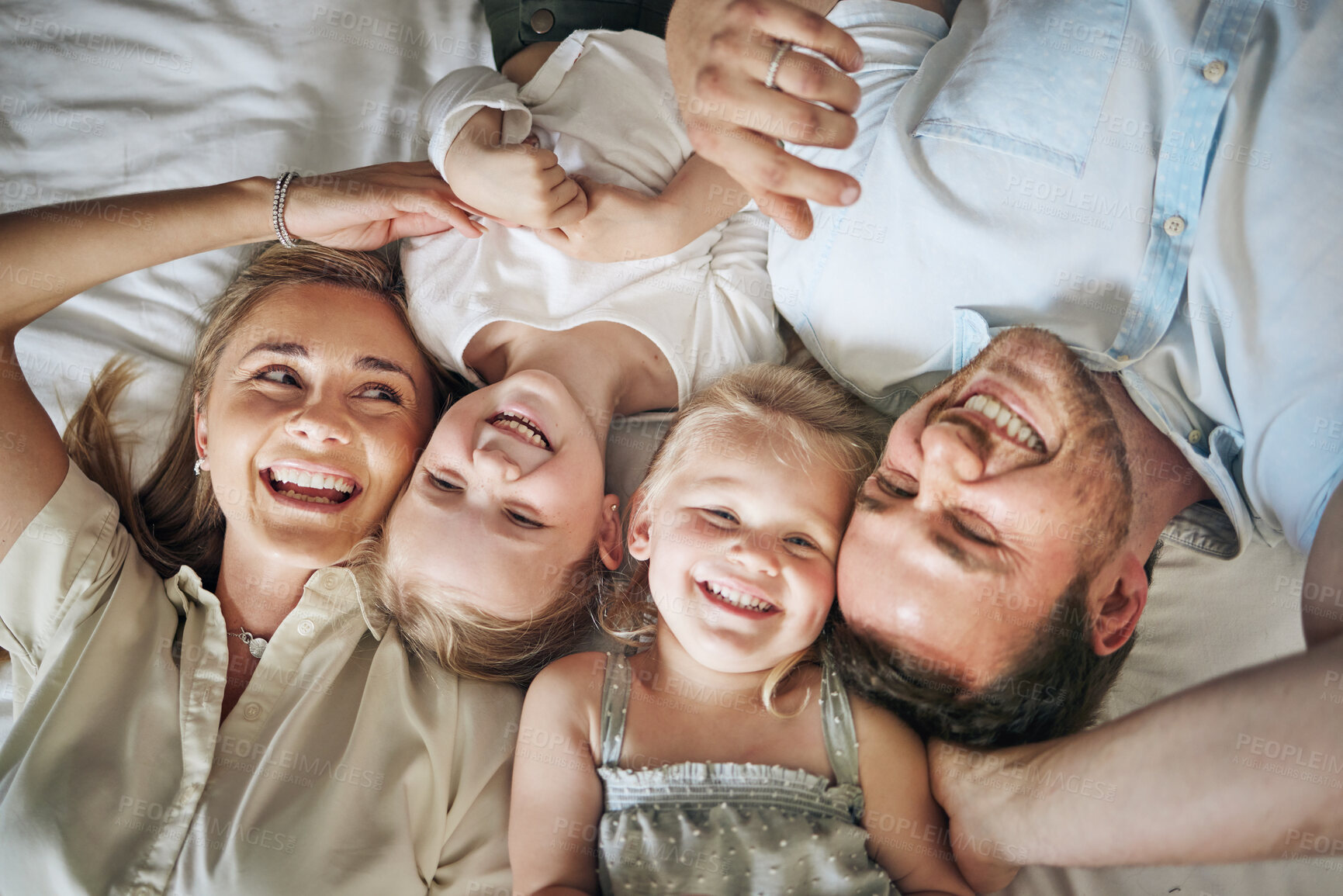 Buy stock photo Portrait, relax and kids with parents on bed for bonding, security and having fun together. Happy, home and girl children laying with family for resting in bedroom at house in London from above.