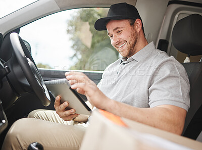 Buy stock photo Cropped shot of a handsome young delivery man using a tablet while sitting in his van