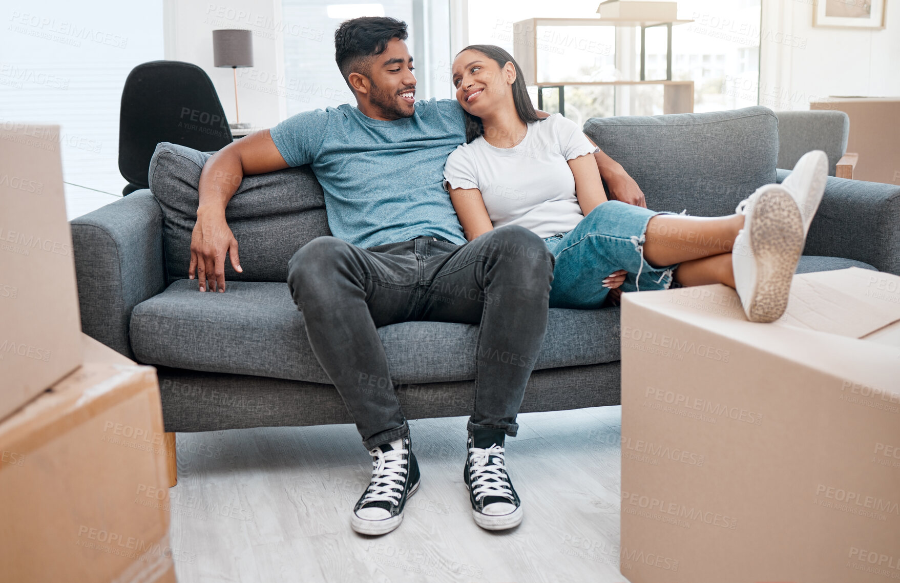 Buy stock photo Full length shot of a young couple sitting on the sofa in their new home