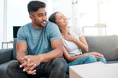 Buy stock photo Shot of a young couple sitting on the sofa in their new home and bonding