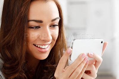 Buy stock photo Happy woman watching videos with a phone with an internet app online to stream or download. Young lady smiling while reading a funny meme or enjoying a web series or movie with a smartphone at home