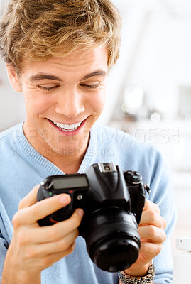 Buy stock photo Man, camera and happy to check photo, home and photography for picture or digital image. Male person, equipment and confident for creative career or journalist, capture memories and shooting smile