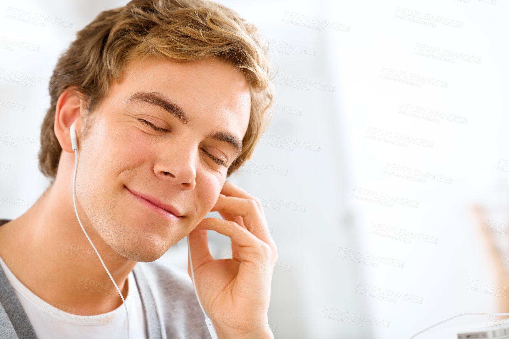 Buy stock photo Face, music and relax with teen boy in home on morning of weekend for audio or radio streaming. Earphones, peace and quiet with smile of happy person in apartment for mental health or wellness