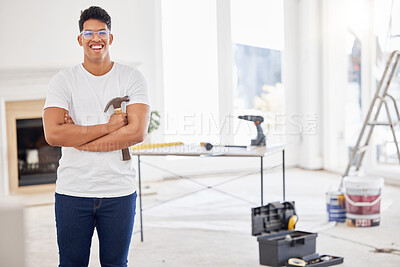 Buy stock photo Shot of a man holding a hammer while busy renovating a house