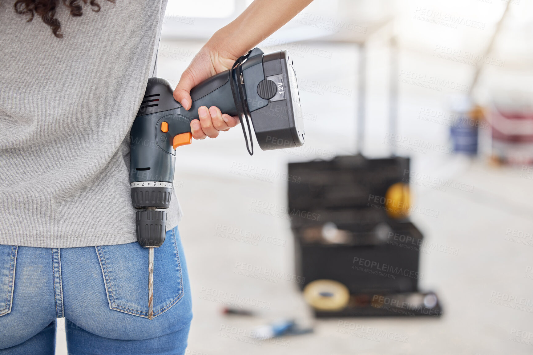 Buy stock photo Woman, back and power drill for diy, project or home improvement as carpenter in house for renovation. Female person, construction tool and contractor in building for maintenance, safety on property