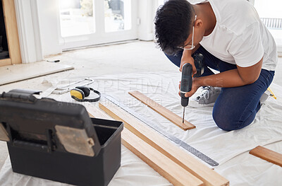 Buy stock photo Shot of a man drilling holes into a wooden plank