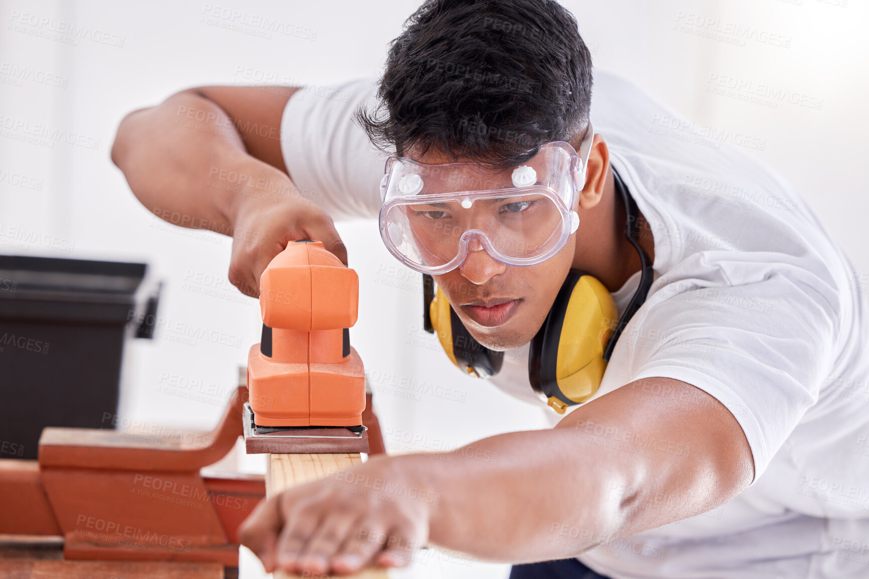 Buy stock photo Sanding, wood and carpenter with glasses, man and serious for construction, service and renovation of home. Maintenance, handyman and person with belt sander, working and remove sawdust in plank