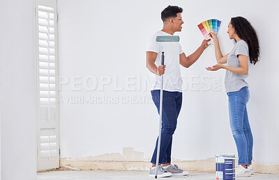 Buy stock photo Shot of a young couple looking at color swatches while painting a room