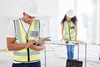 Buy stock photo Shot of a handsome young contractor standing inside and using a clipboard
