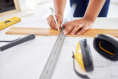 Buy stock photo Cropped shot of an unrecognisable contractor standing alone inside and using a ruler to draw up building plans