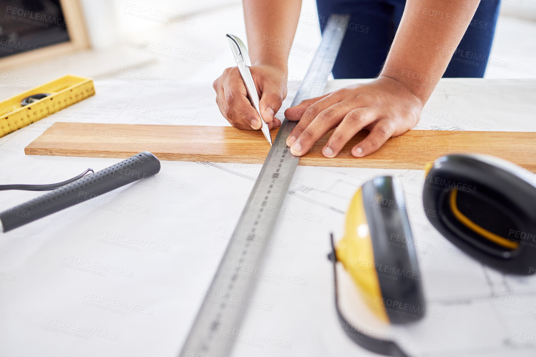 Buy stock photo Cropped shot of an unrecognisable contractor standing alone inside and using a ruler to draw up building plans