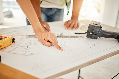 Buy stock photo Cropped shot of two unrecognisable construction workers standing together and having a discussion while looking at building plans